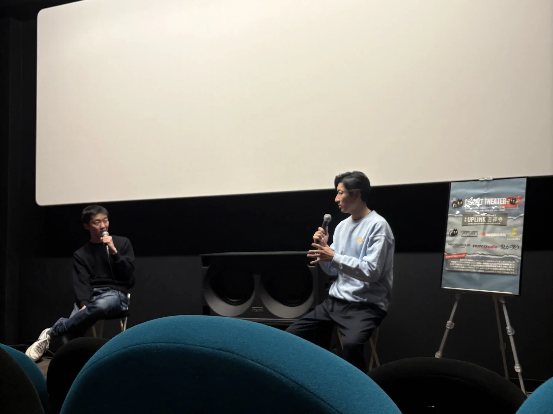 映画館のスクリーン前でトークイベントを行うSAMANSA共同代表の遠山氏（左）とこねこフィルムプロデューサーの三野氏（右）