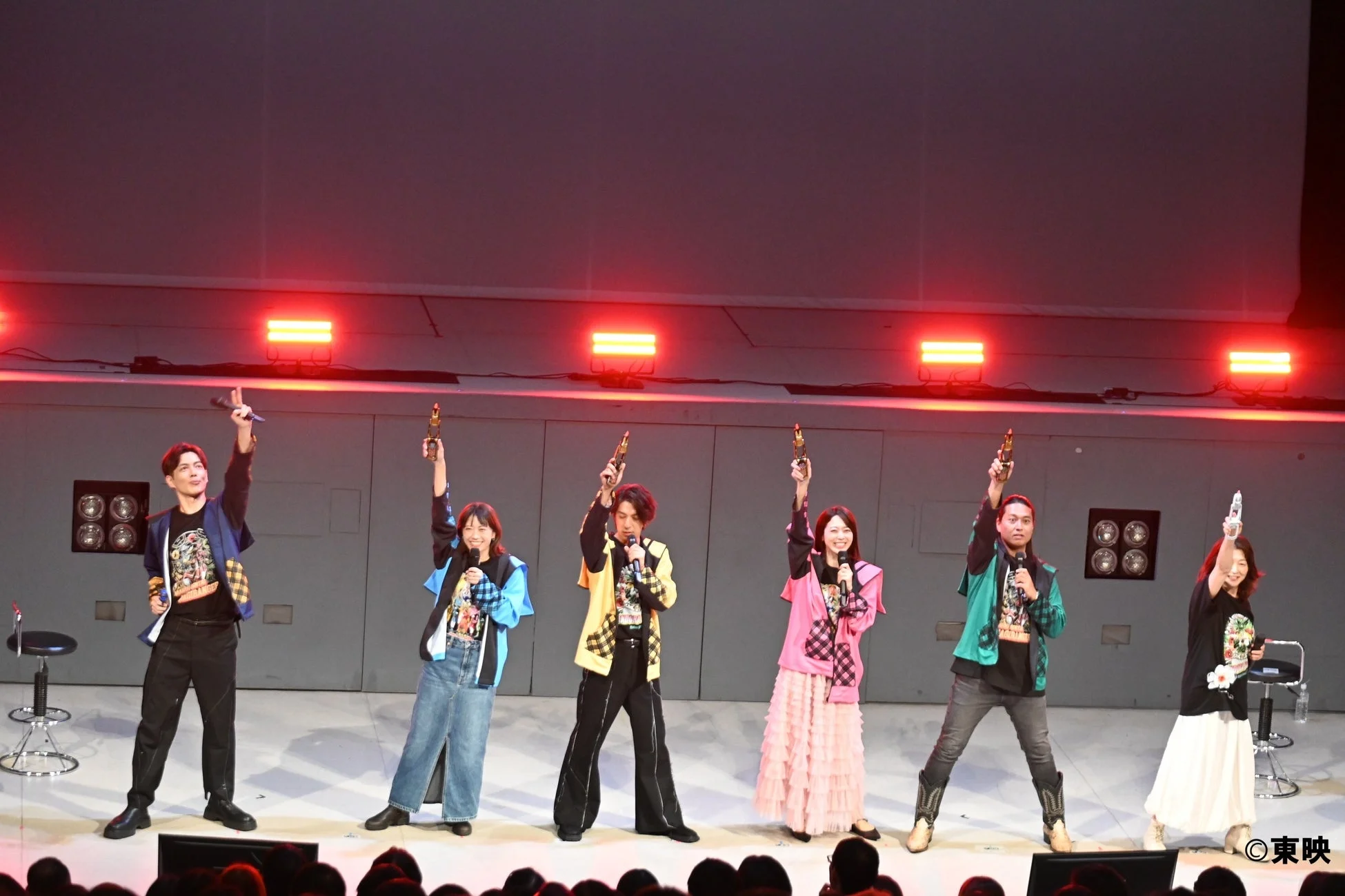 ステージでポーズをとる出演者たち