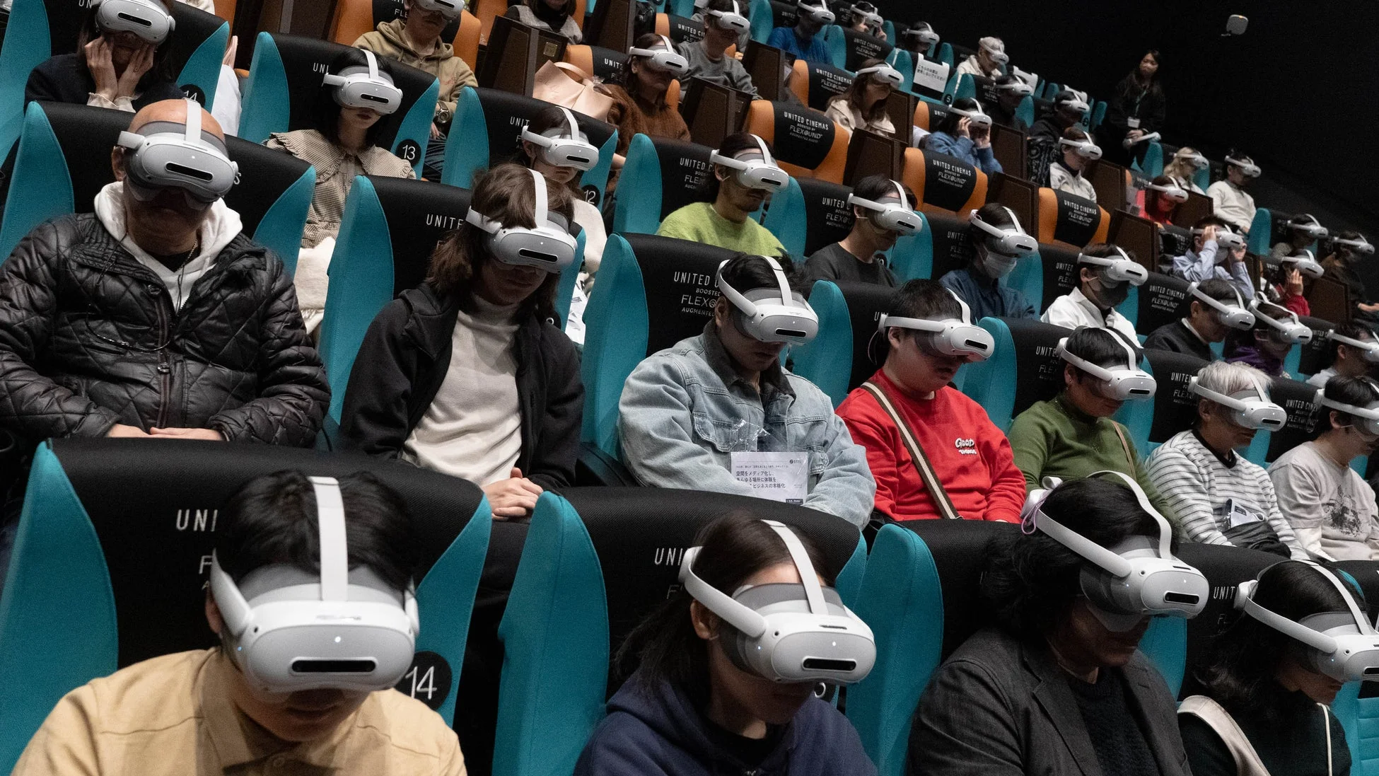 VRヘッドセットを装着した観客たちが映画館でVR体験をしている様子