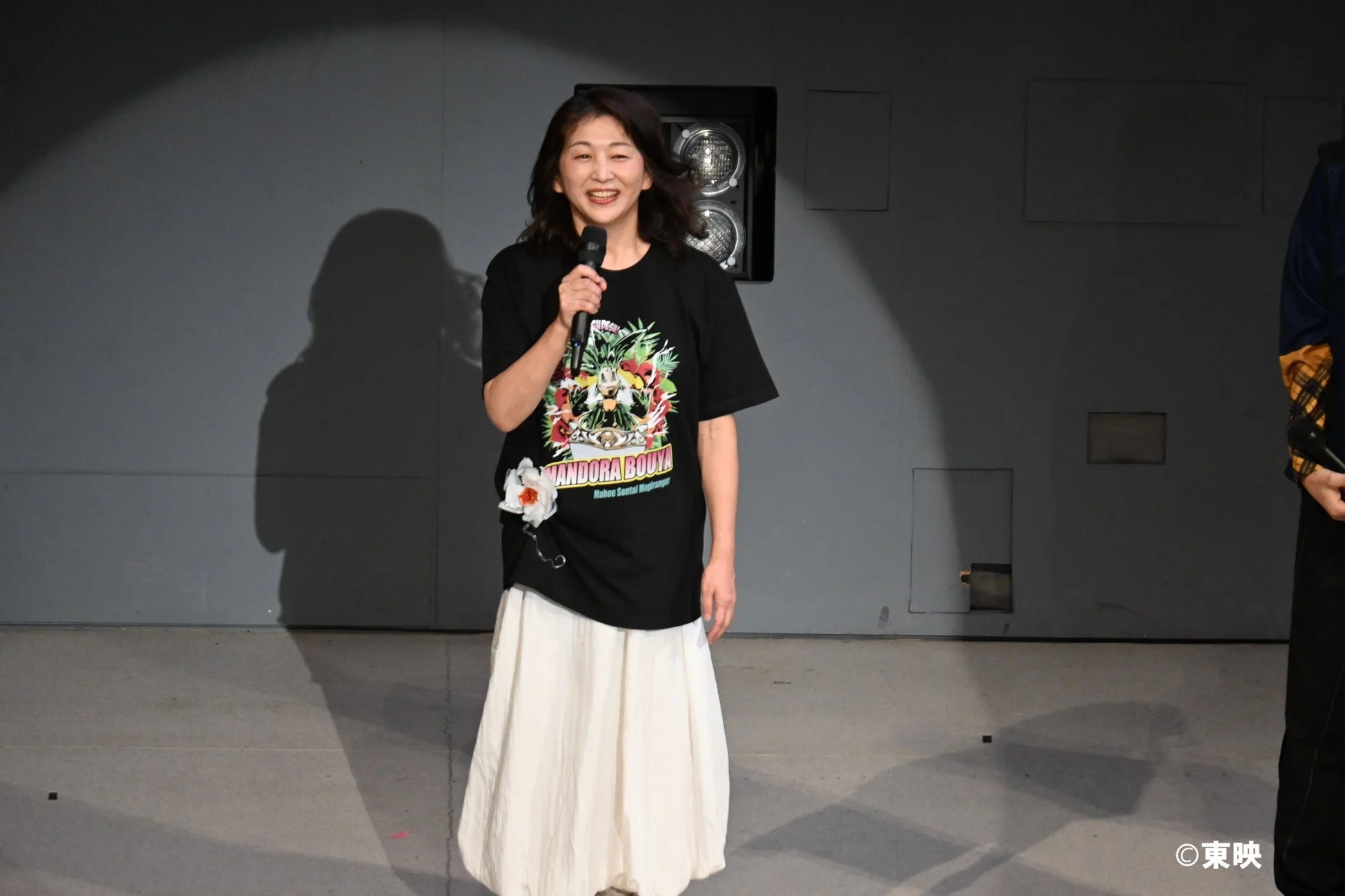 ステージでマイクを持つ女性