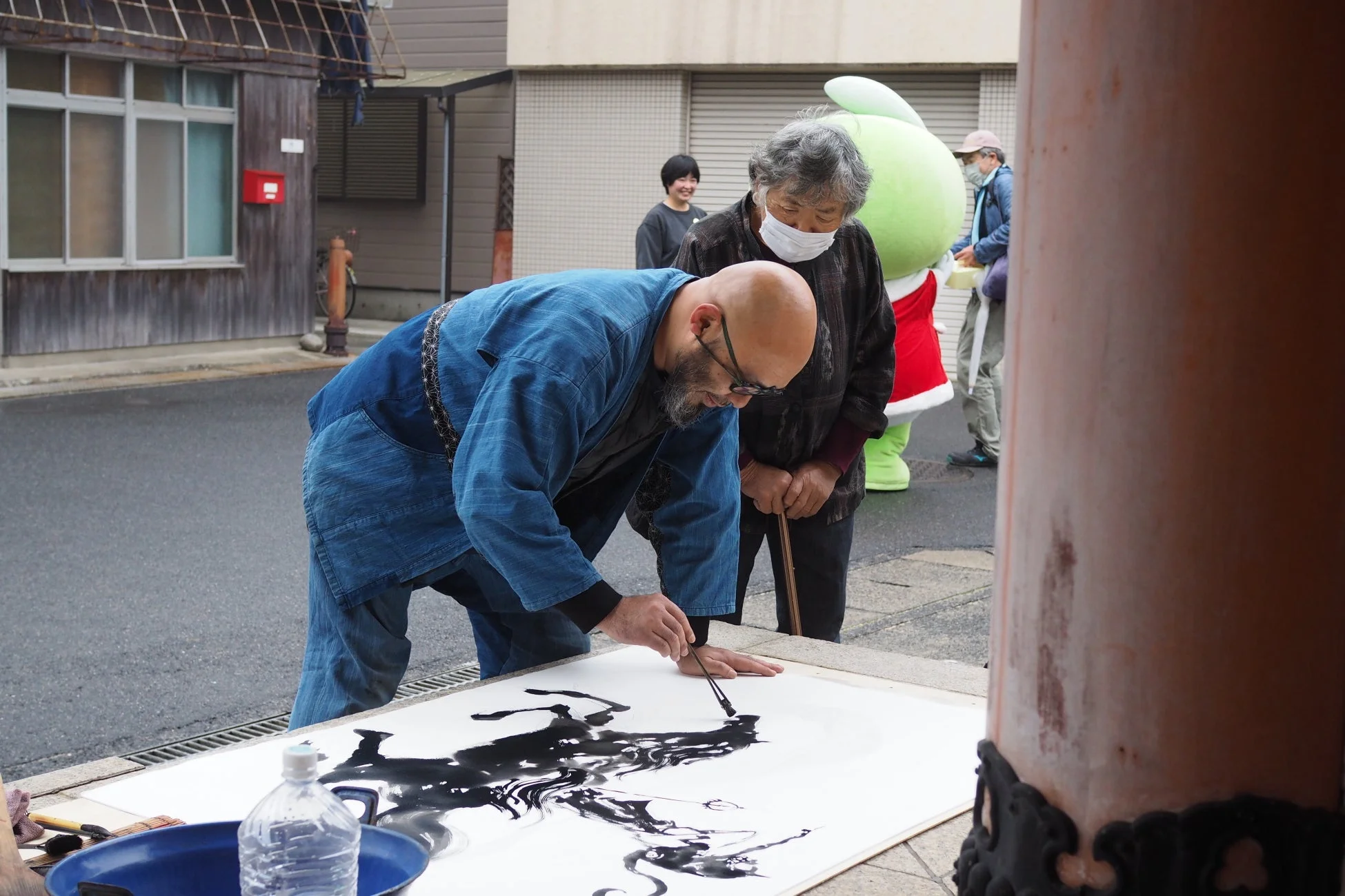 屋外で墨絵を描く柳生忠平館長