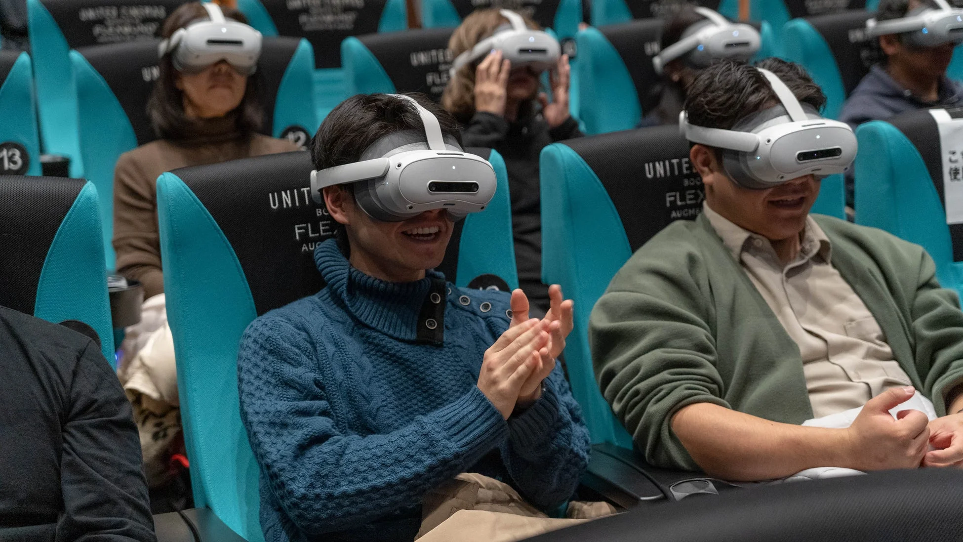 VRヘッドセットを装着し、拍手する観客の様子