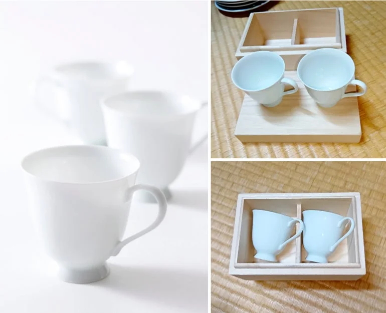 白い陶器のカップが複数写っており、一部は木箱に収納されたペアセットとして展示されています。シンプルで上品なデザインの食器です。