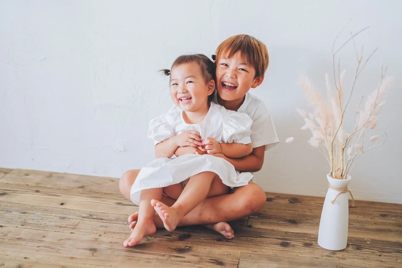 抱き合って笑顔を見せる幼い兄妹