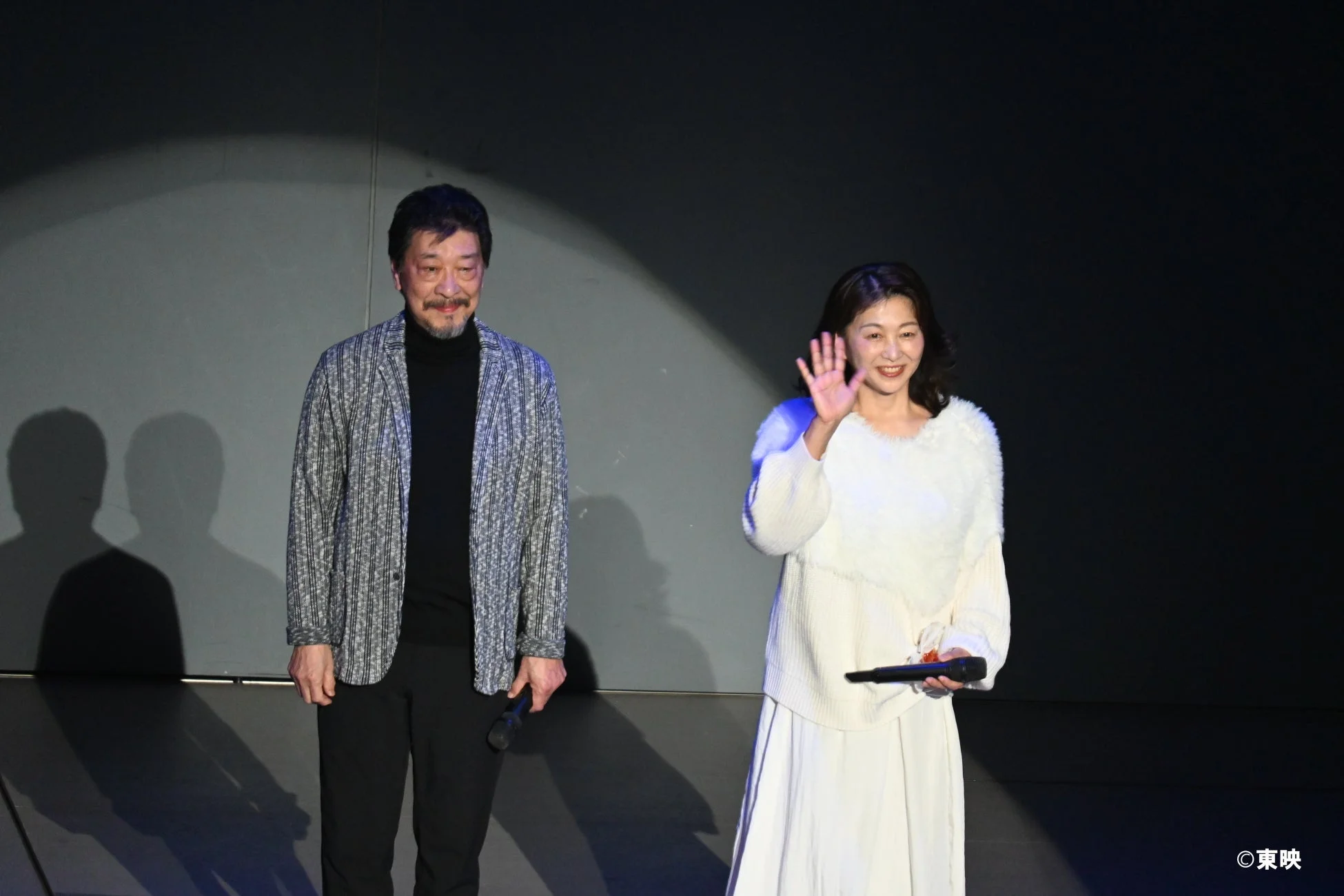 ステージでマイクを持つ男女