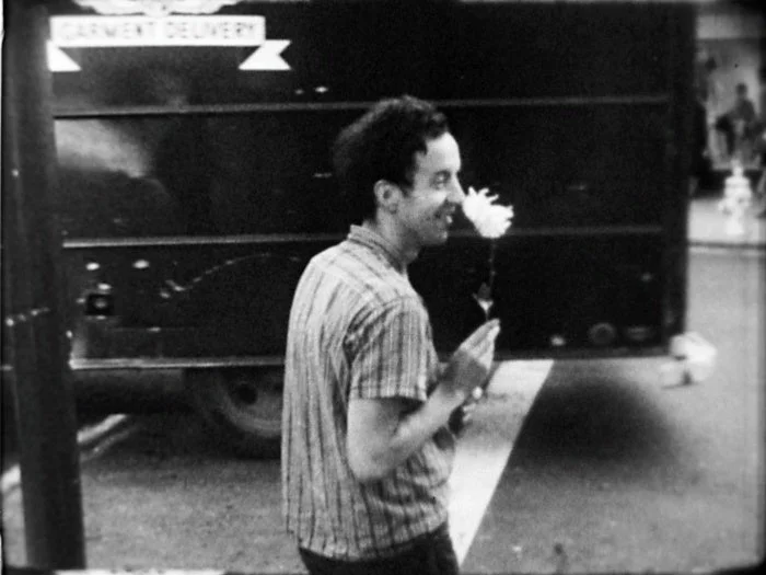 ストライプシャツの男性と白い花