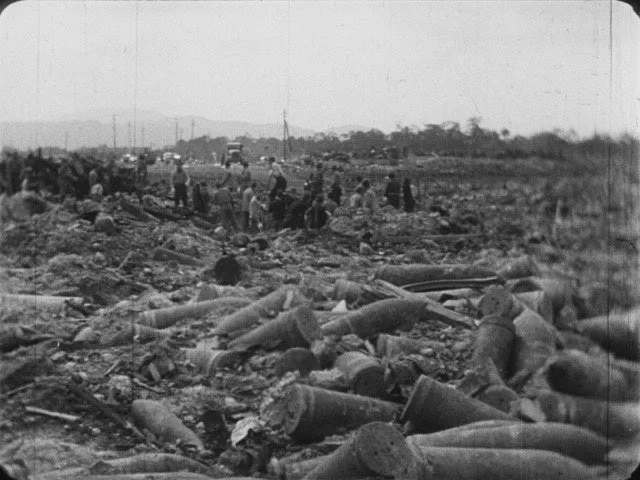 砲弾や爆弾の残骸が散乱する土地に集まる人々