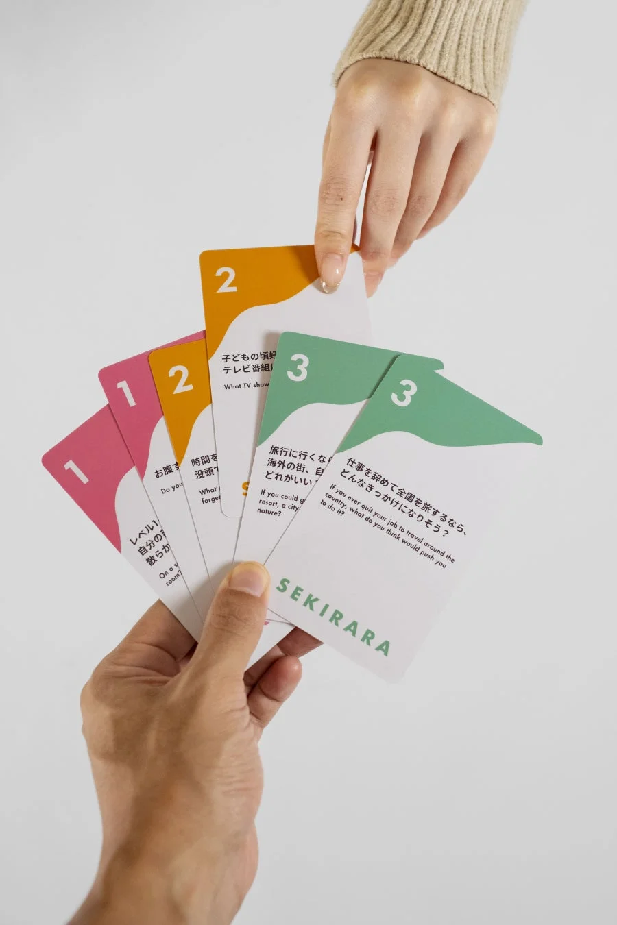 複数の質問カードを持つ手元