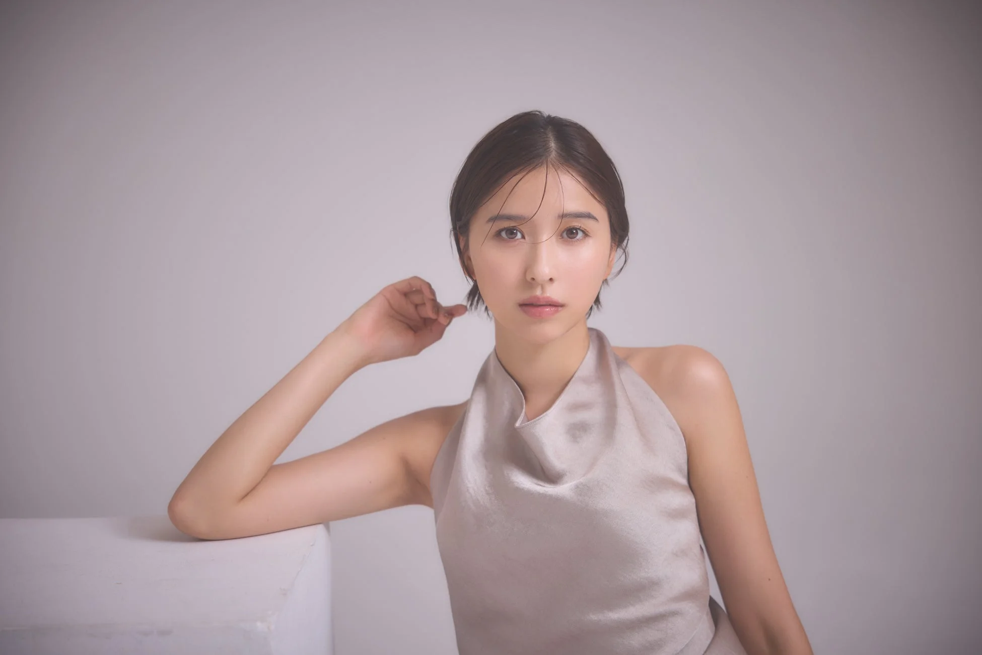 ベージュのトップスでカメラを見つめる玉井詩織さん