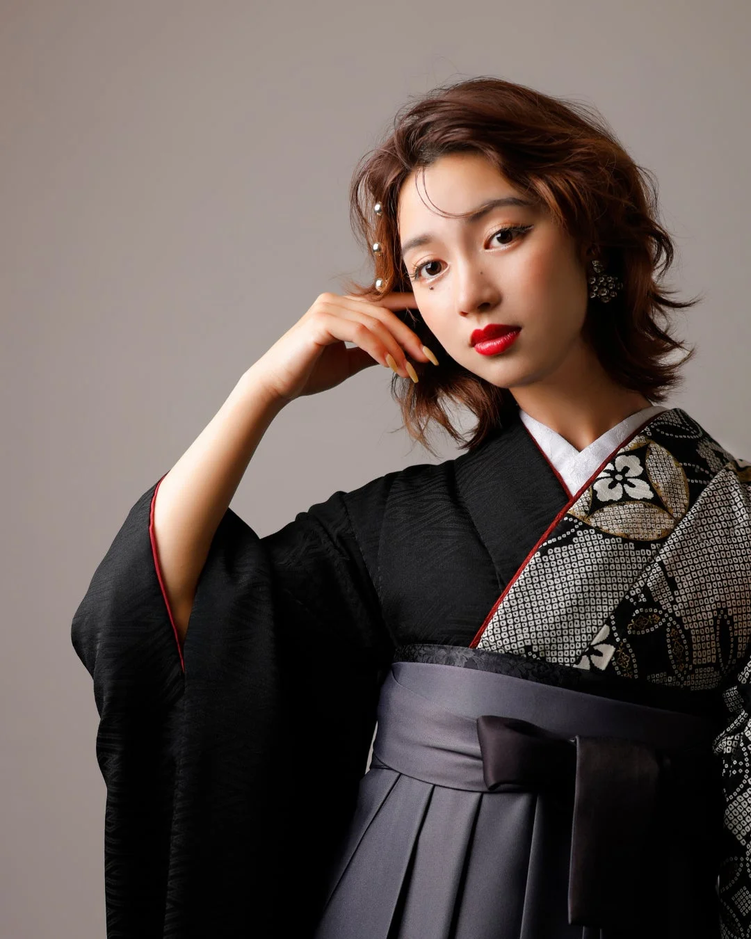 黒い着物とグレーの袴を着用した日本人女性