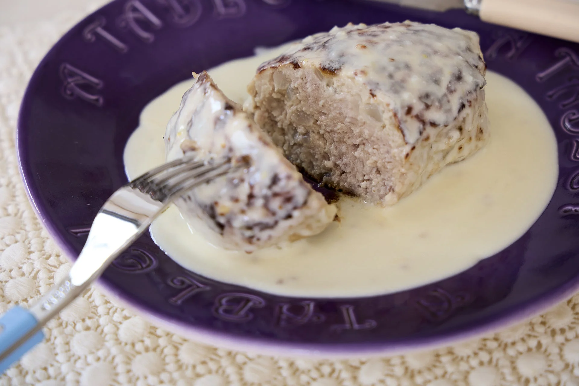 白いソースがかかったハンバーグのような料理