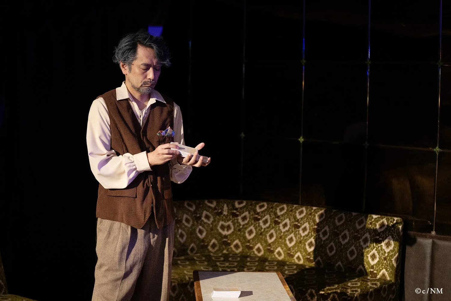 カードを見つめる男性キャスト