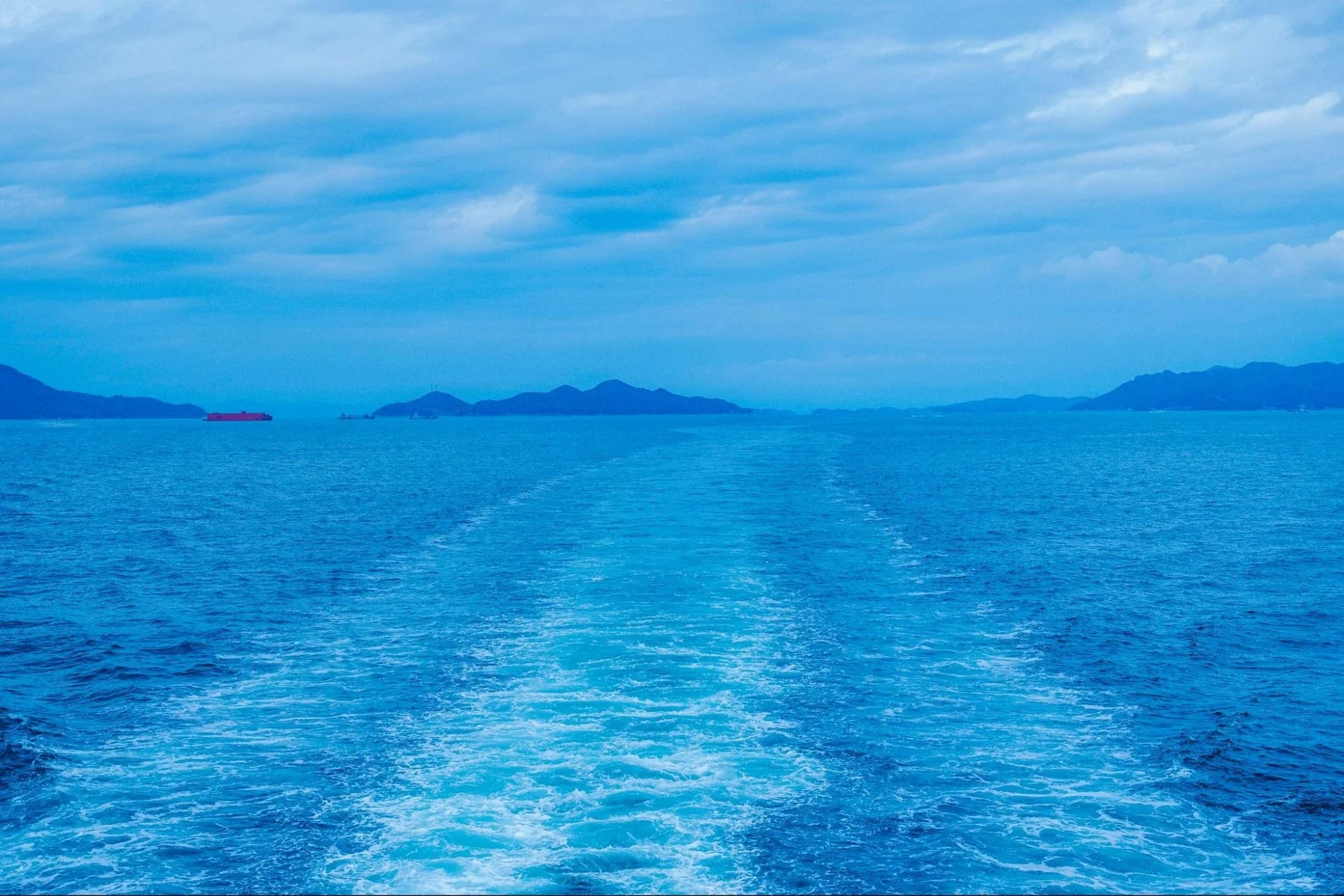 青い海と船の航跡、遠くに見える島々
