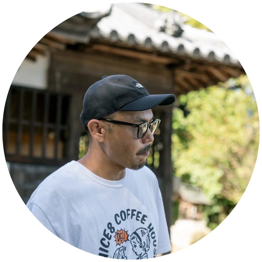 黒いキャップと眼鏡、白いTシャツを着用した男性の横顔