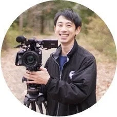 プロフェッショナルなビデオカメラと三脚を持つ男性