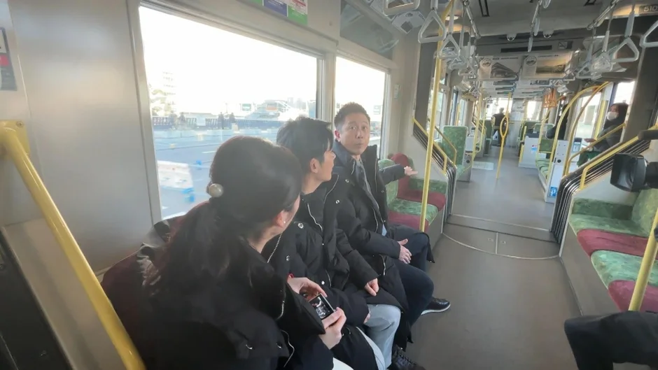 路面電車内で会話するロザン