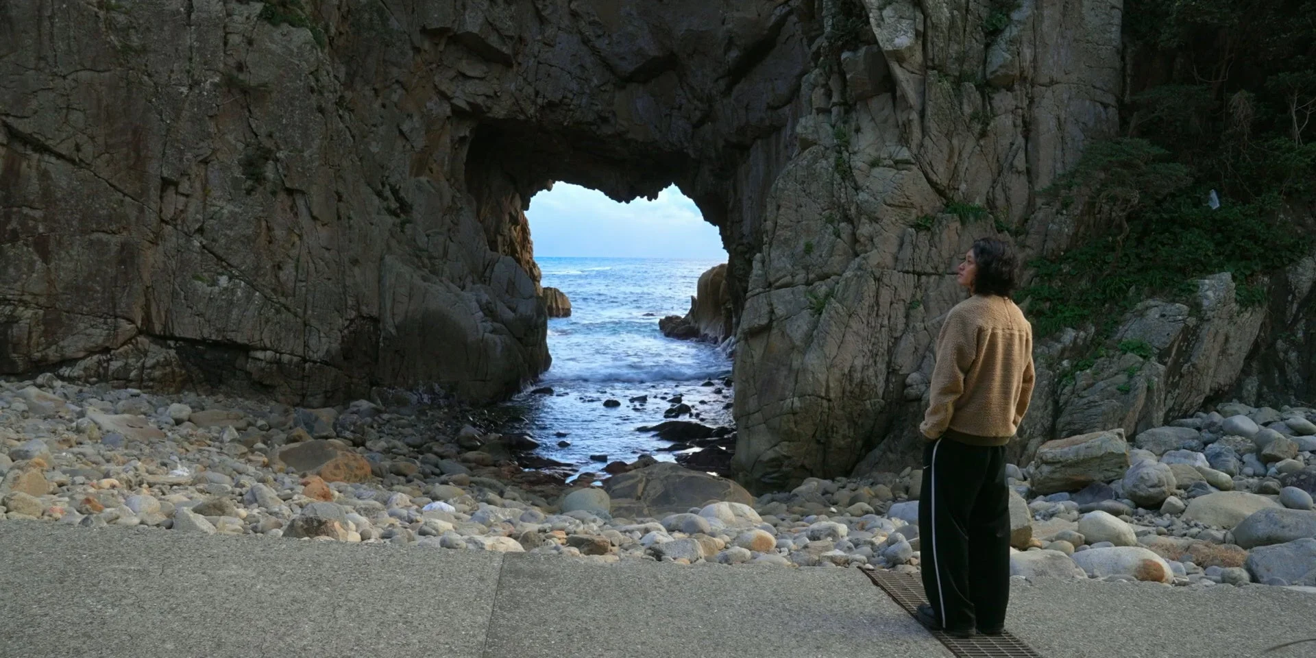 岩のアーチを通して海を望む景色