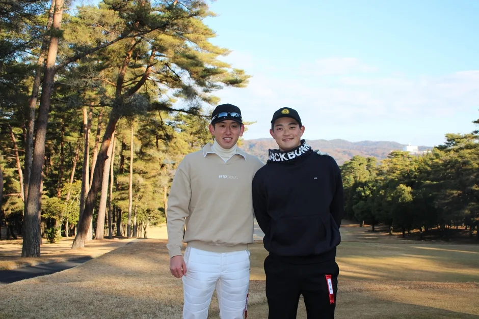 ゴルフコースで笑顔を見せる2人の男性