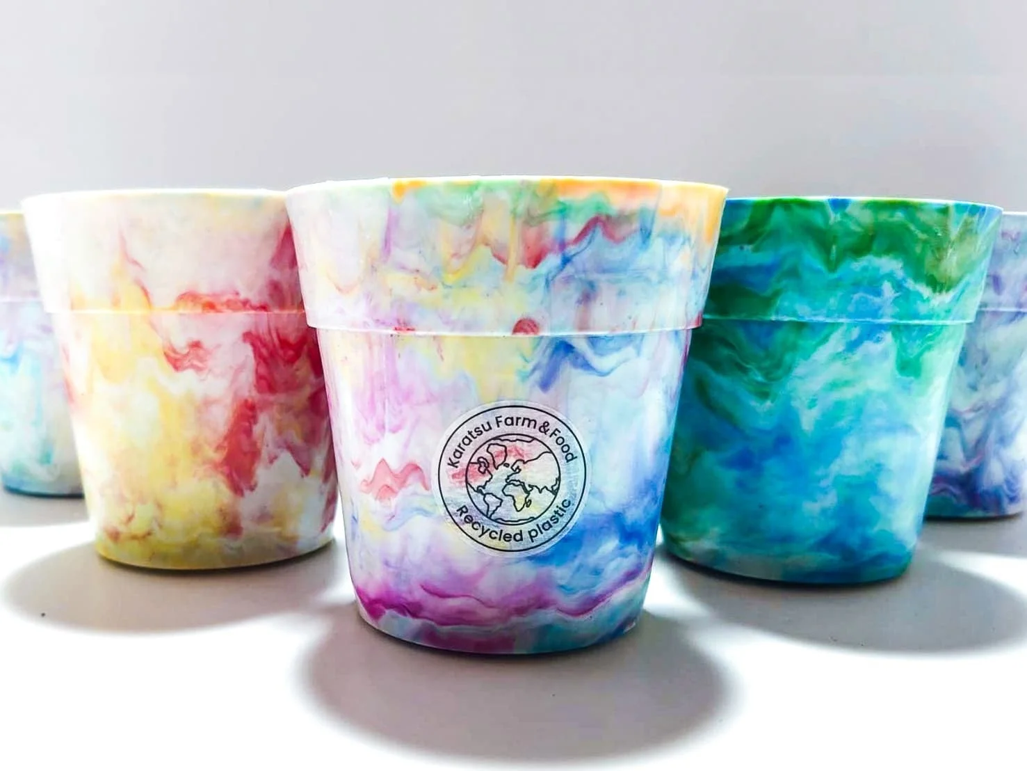 リサイクルプラスチック製のカラフルなカップが複数並べられています