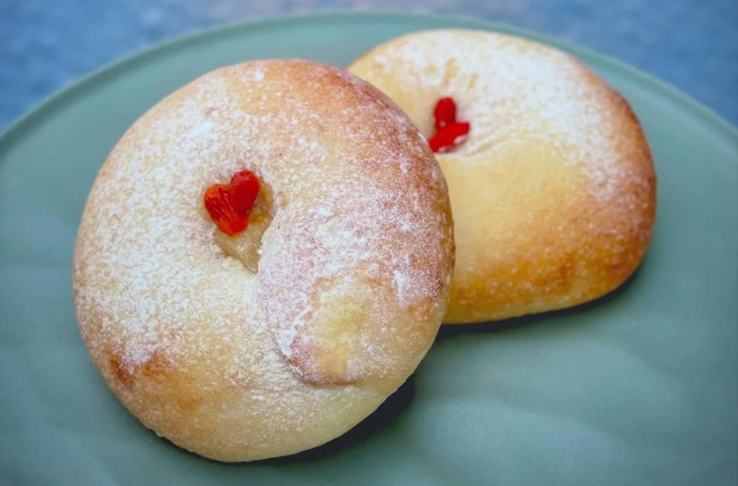 粉砂糖がまぶされた2つの丸いパン