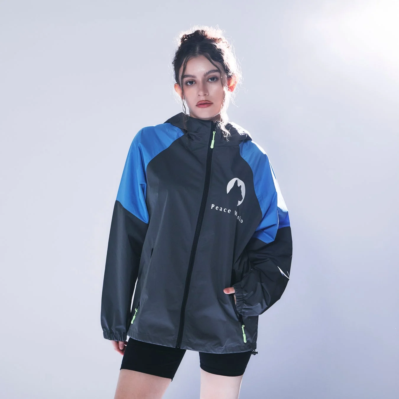 青とグレーのウィンドブレーカーを着用した女性