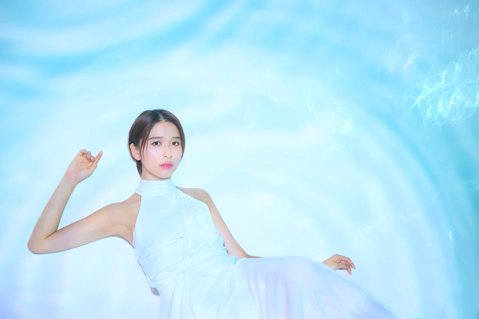 幻想的な青い背景でポーズをとる玉井詩織さん