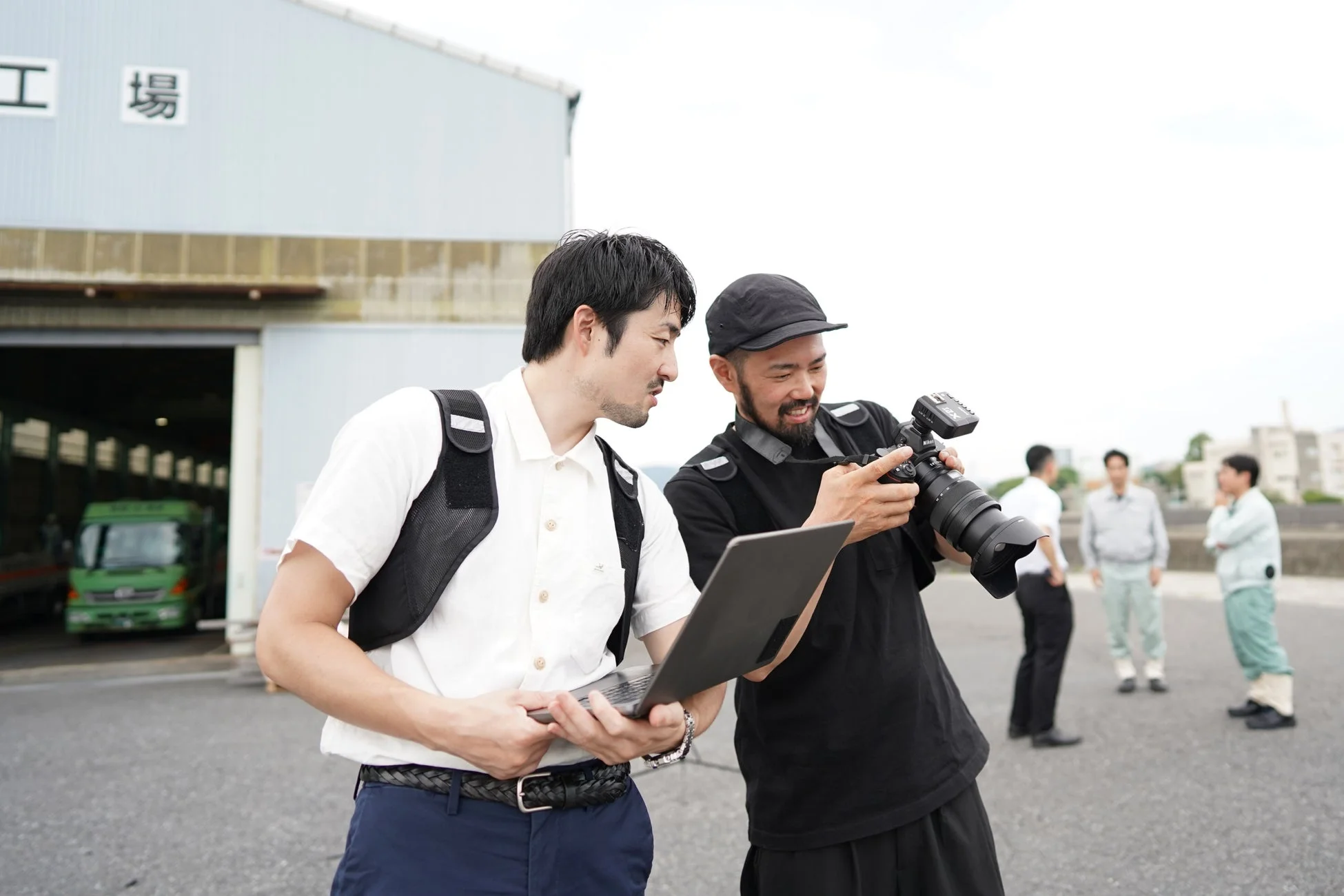 工場で撮影内容を確認するカメラマンとスタッフ