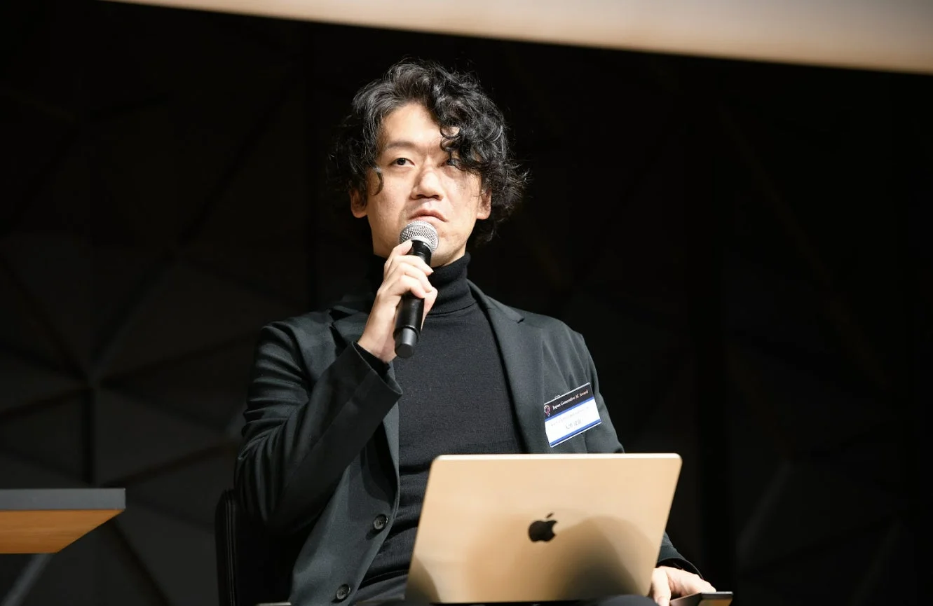 マイクを手に話す男性