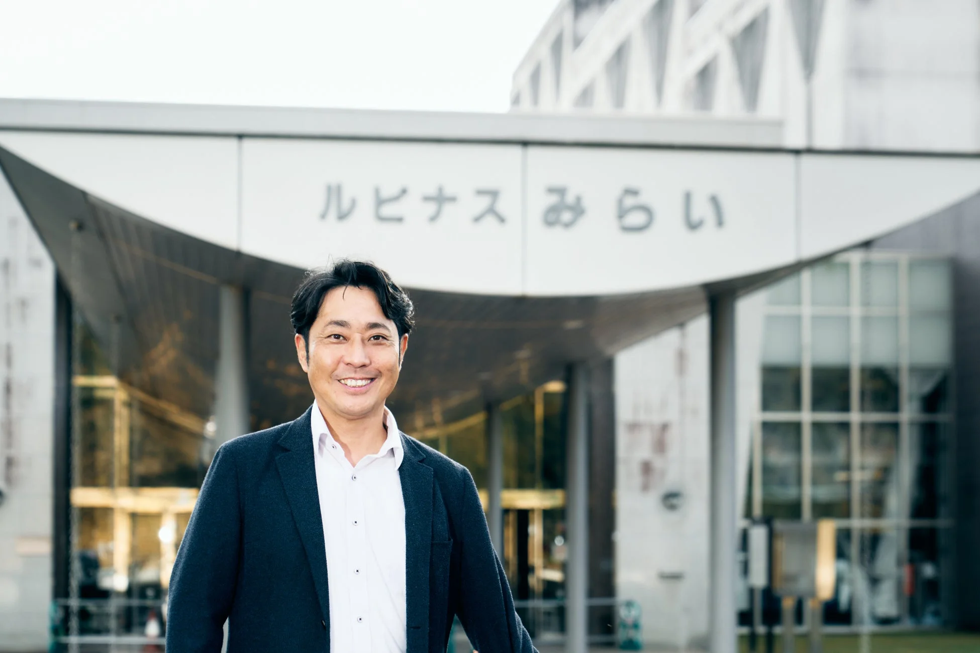 男性,日本人,笑顔,ビジネスマン,スーツ,建物,現代建築,屋外,ルピナスみらい,ポートレート