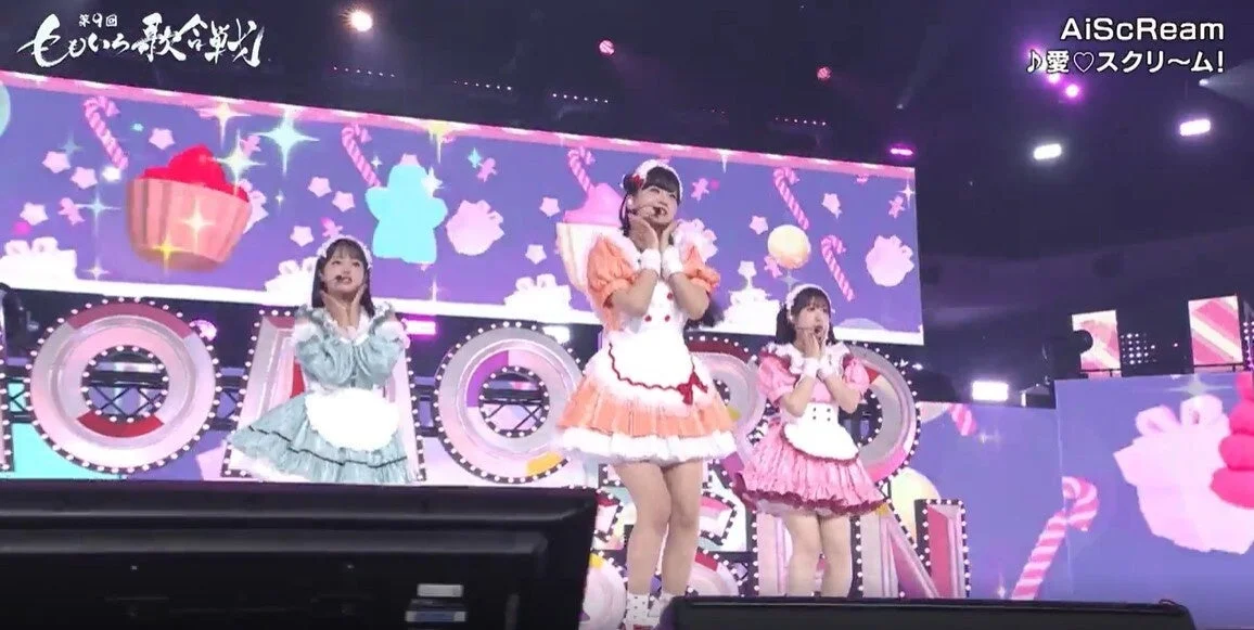 第9回ももいろ歌合戦のステージで、可愛らしいメイド服を着た3人の女性アイドルがパフォーマンスをしています