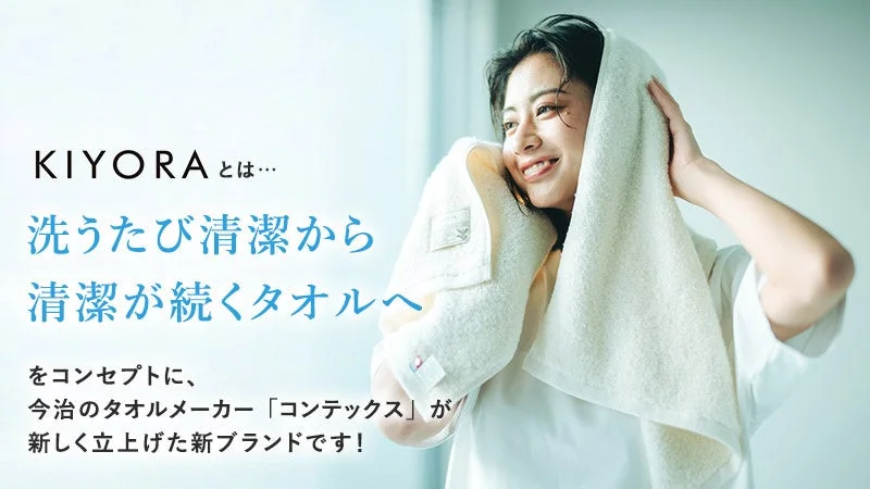 「洗うたび清潔から清潔が続くタオルへ」をコンセプトに、今治のタオルメーカー「コンテックス」が立ち上げた新ブランド「KIYORA」の広告画像です。白いタオルで髪を拭く笑顔の女性が写っており、清潔感と快適さを表現しています。