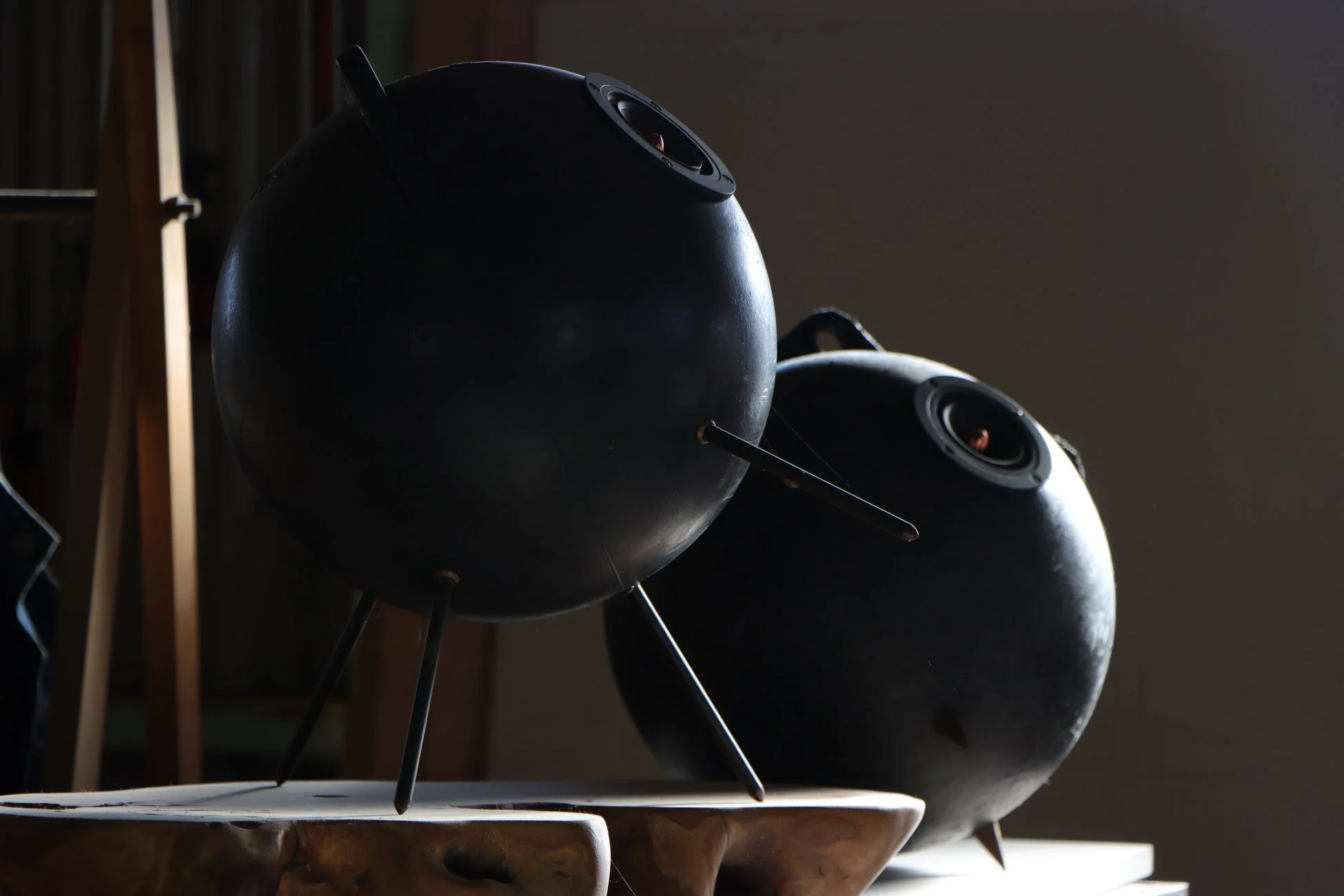 薄暗い空間に置かれた二つの黒い球体状のオブジェ、またはスピーカーの画像です。