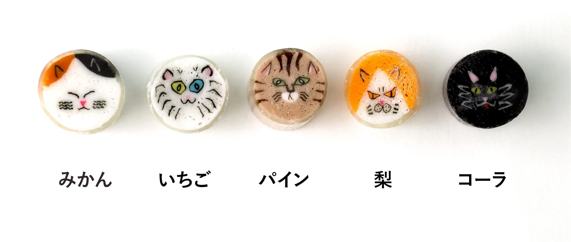 猫の顔がデザインされた5種類の金太郎飴が並んでいます。みかん、いちご、パイン、梨、コーラの味があり、それぞれ異なる表情の猫が特徴的で可愛らしいです。