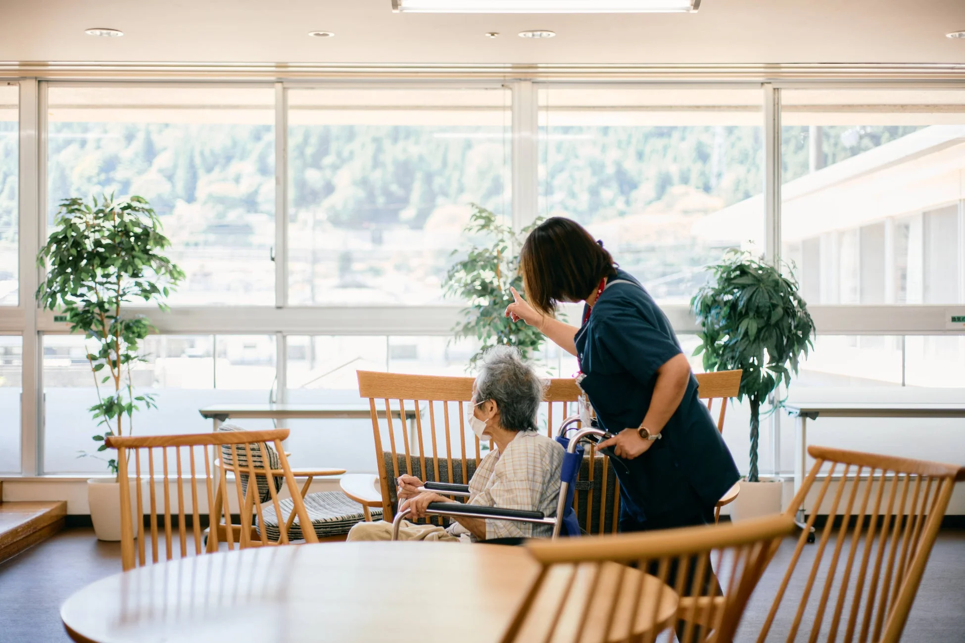 車椅子の高齢者に話しかける介護士