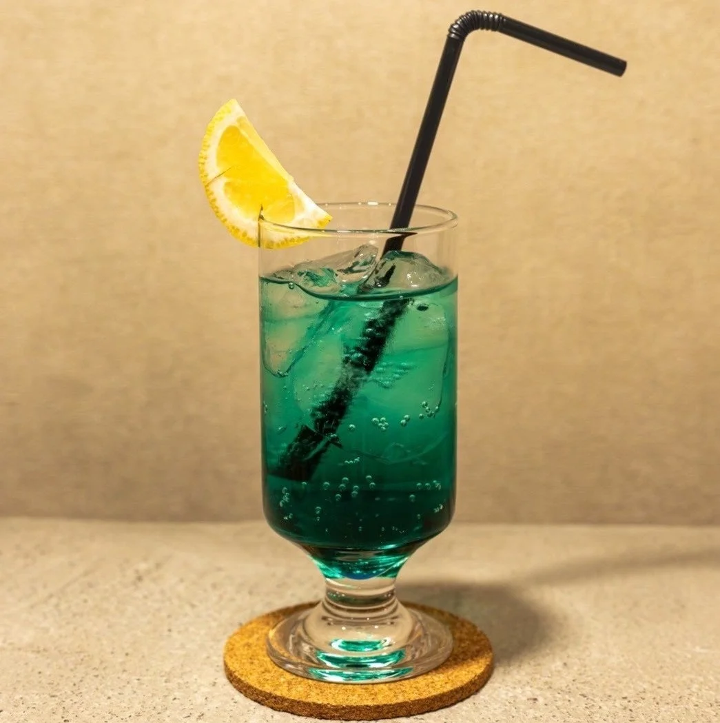 青緑色のドリンクにレモンスライスとストロー