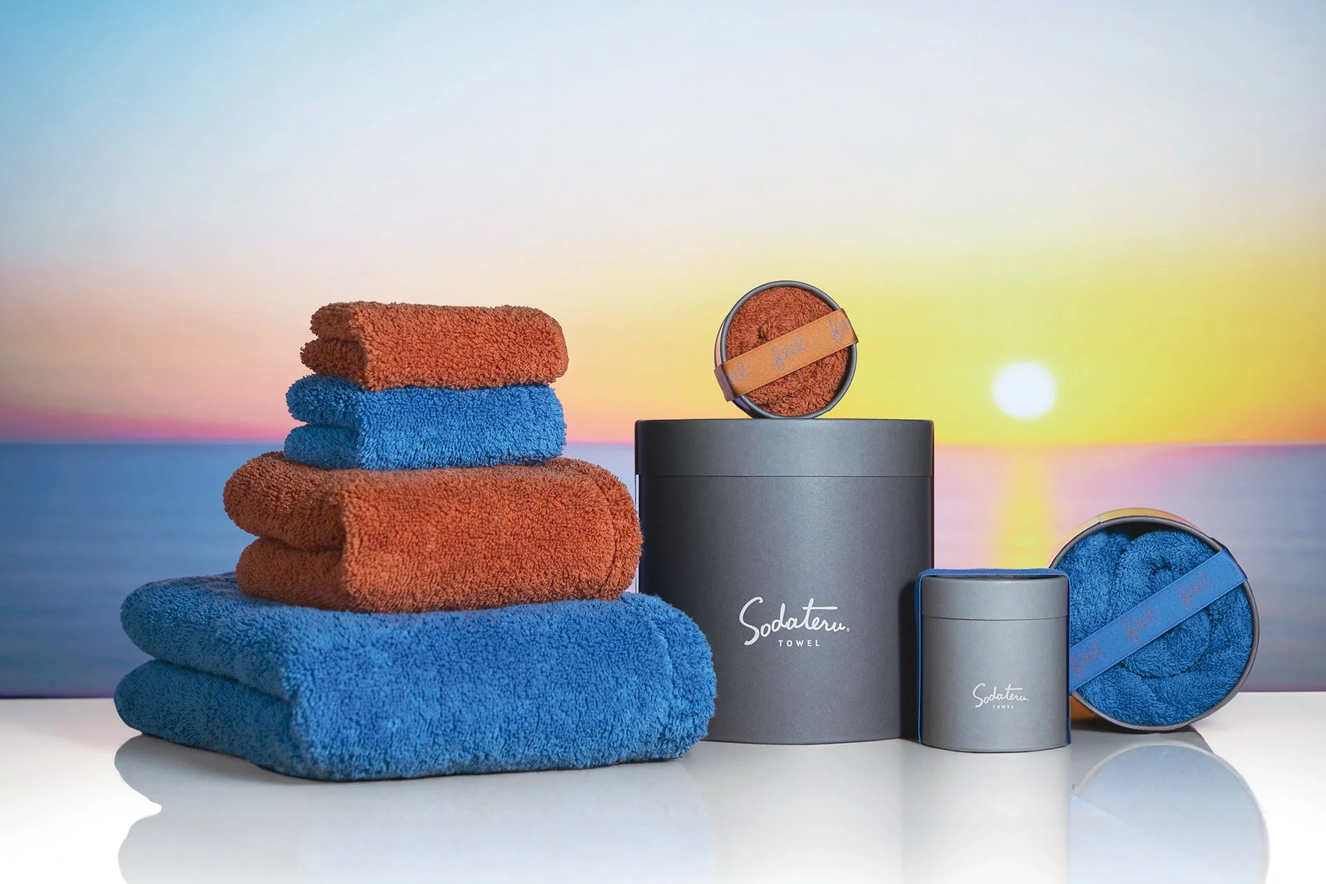 夕焼けを背景にしたオレンジと青のタオル