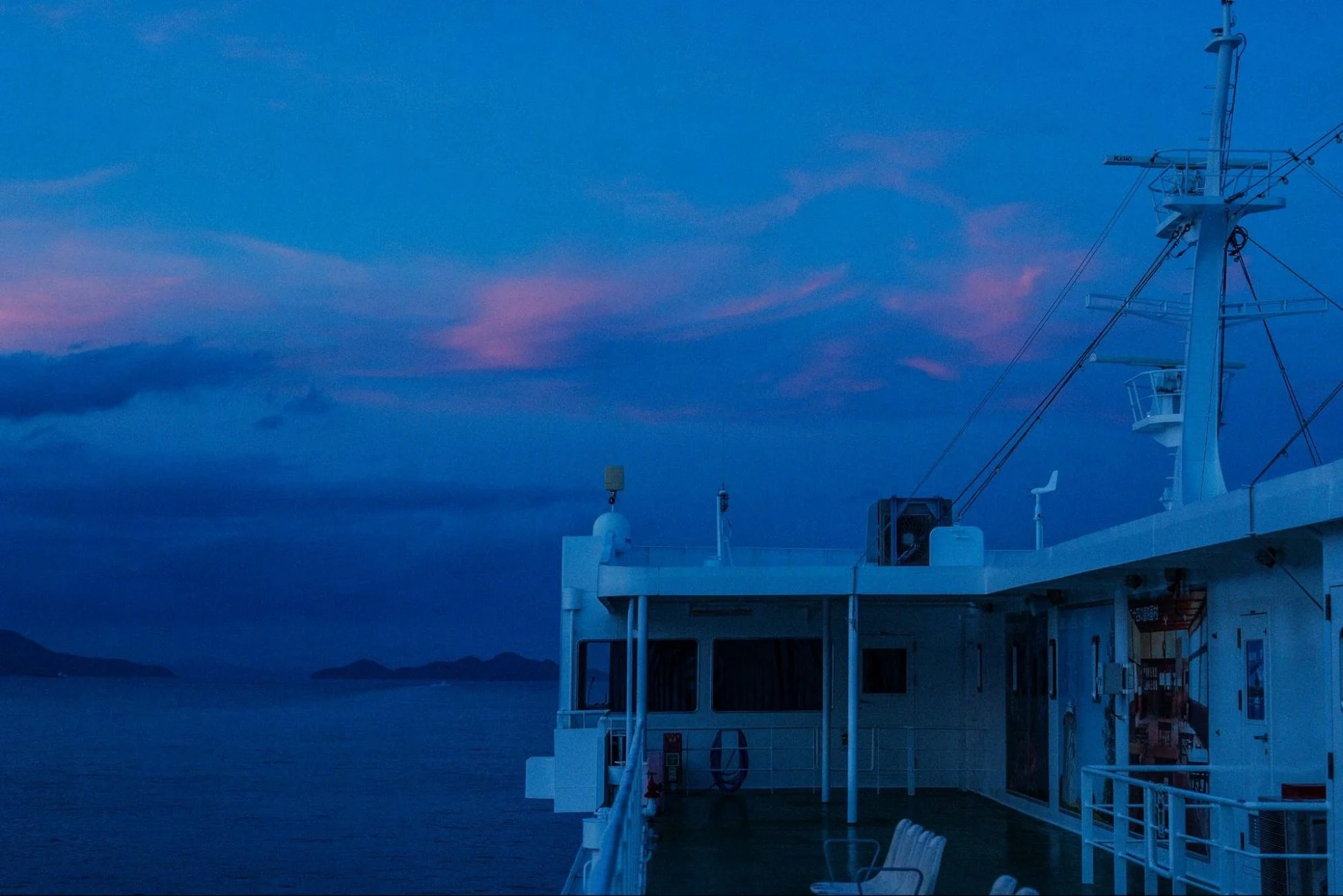 夕暮れか夜明けのフェリーデッキから外を眺める風景