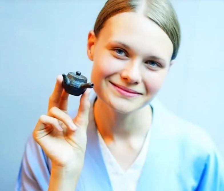 笑顔の女性が小さな急須を持つ