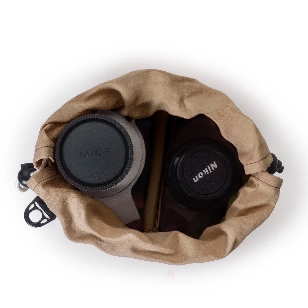 ベージュの巾着袋の中にSONYとNikonのレンズキャップ