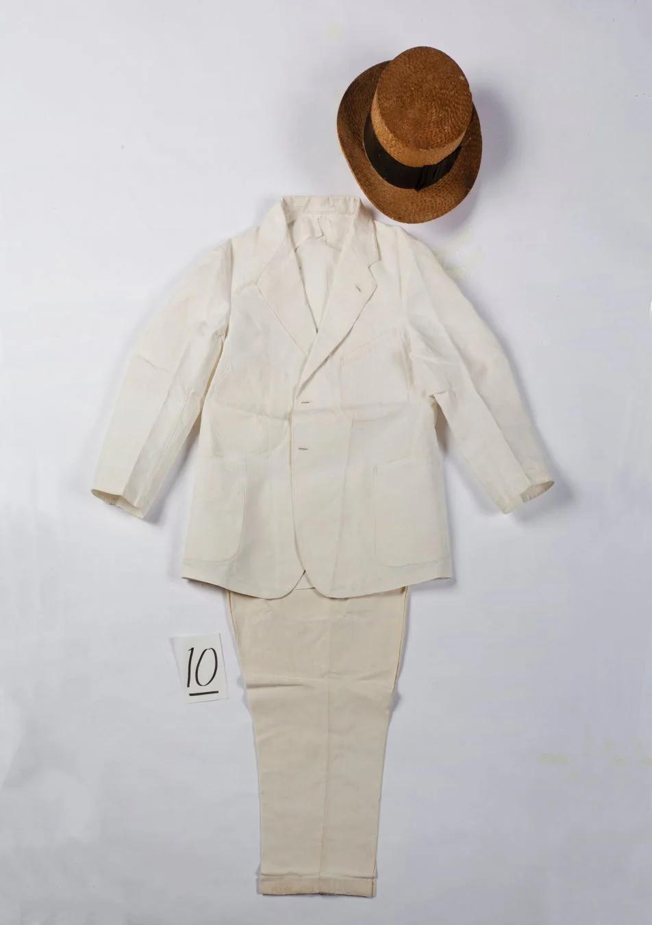 クリーム色のスーツと麦わら帽子