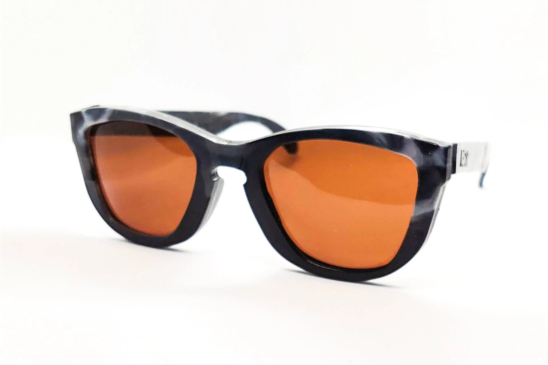 黒いマーブル模様のフレームと鮮やかなオレンジ色のレンズが特徴的なサングラス