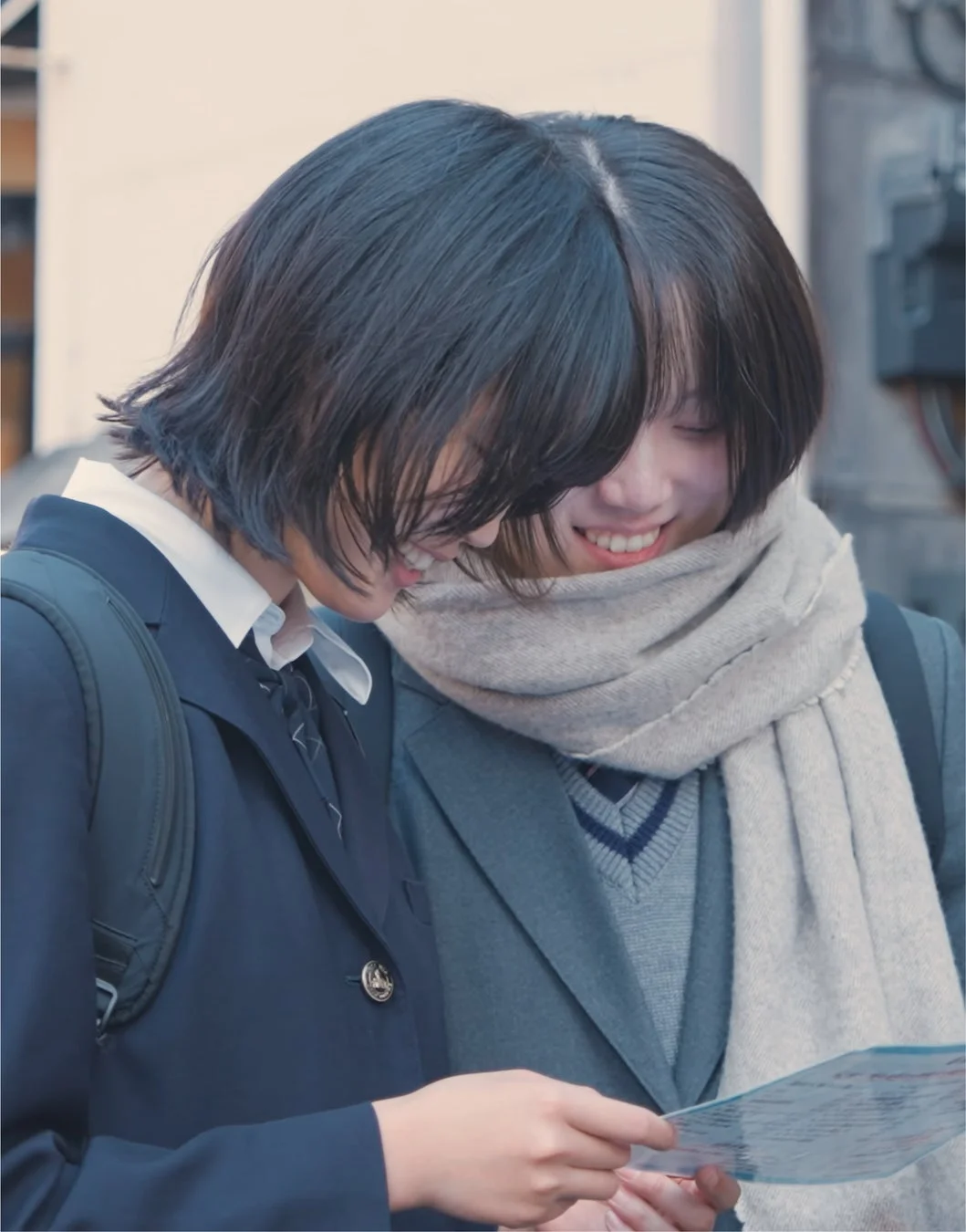 二人の女子学生が笑顔で地図を見ている様子