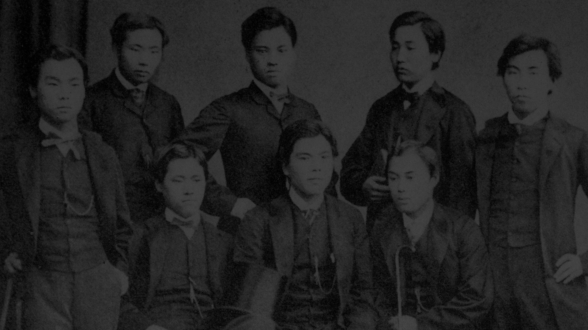 西洋のフォーマルな服装をした数人の日本人男性が写る白黒の集合写真です。