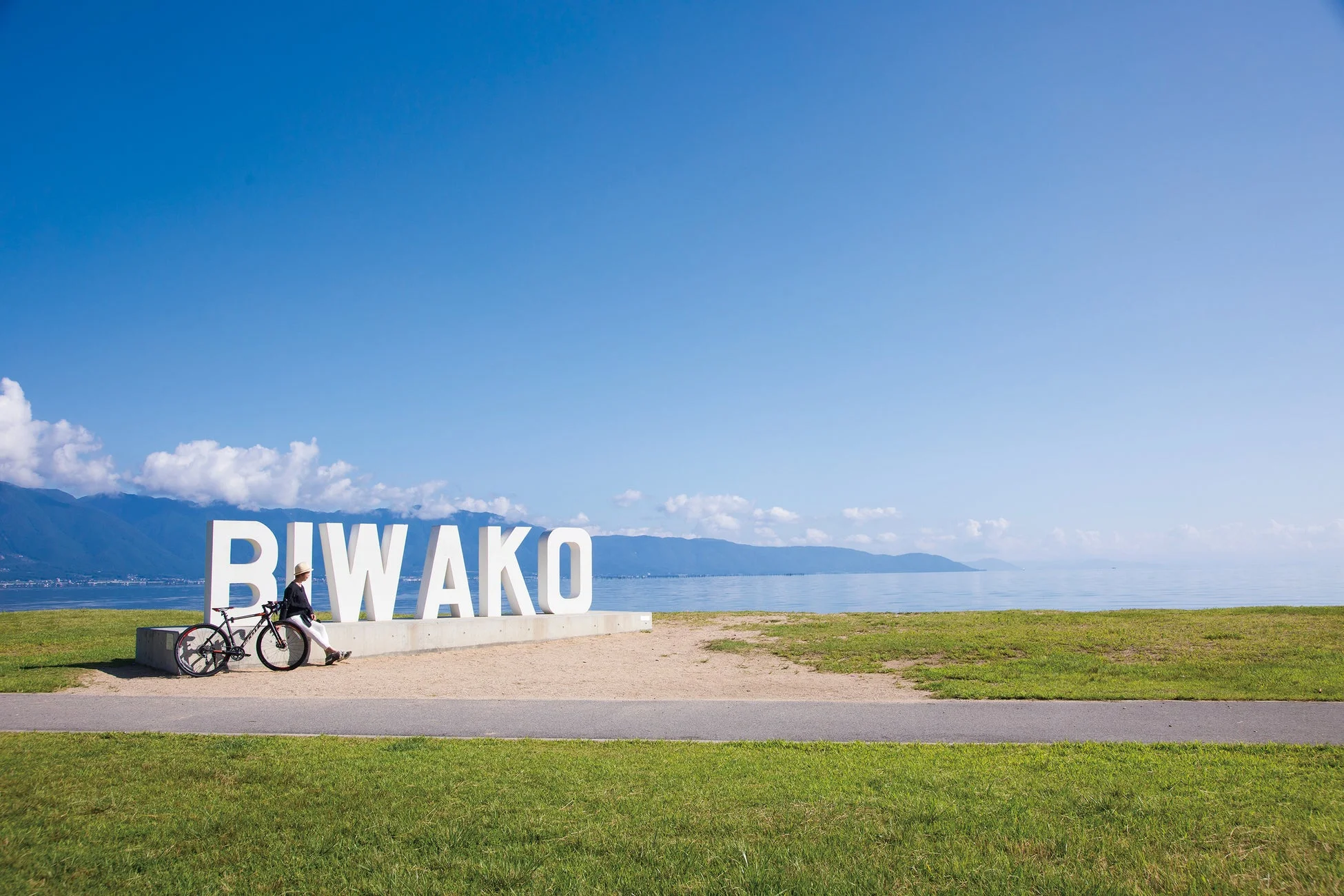 琵琶湖のモニュメントとサイクリスト