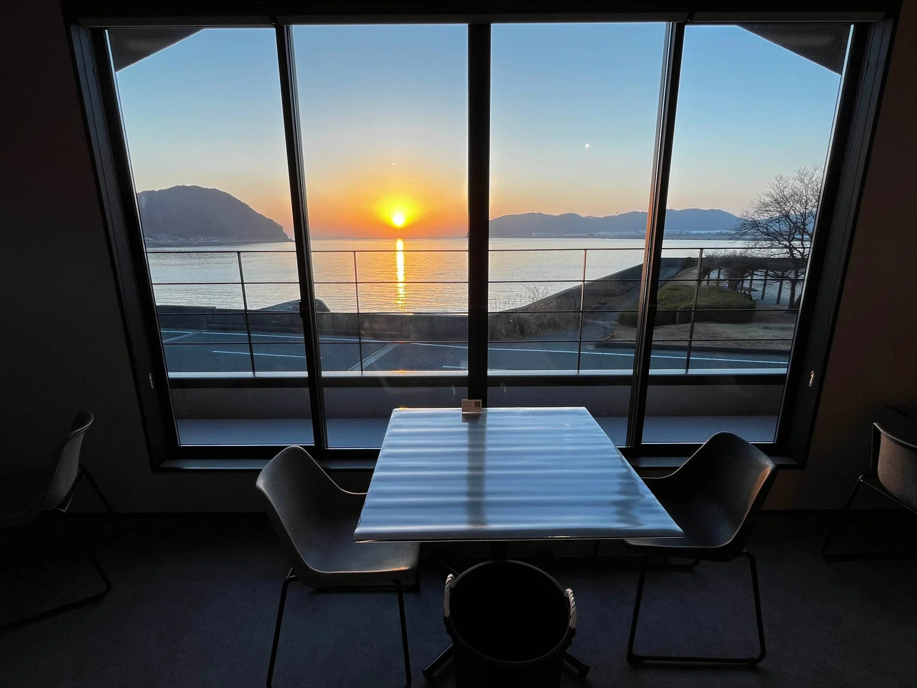 窓から見える夕焼けの海