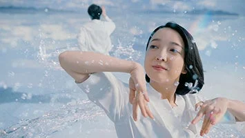 白い服の女性と男性が水しぶきの中でポーズをとる