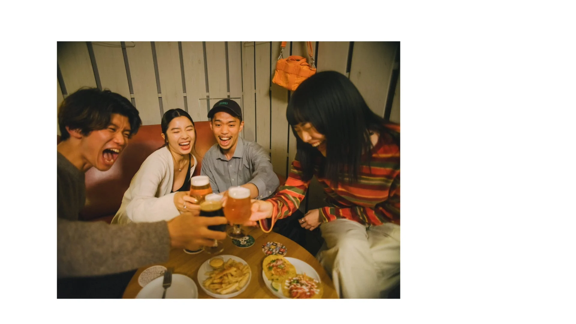 居酒屋でビールを片手に乾杯する友人たち