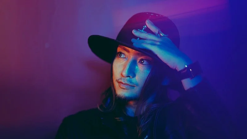 黒いハットを被り、ネオンライトに照らされるDANTZ氏