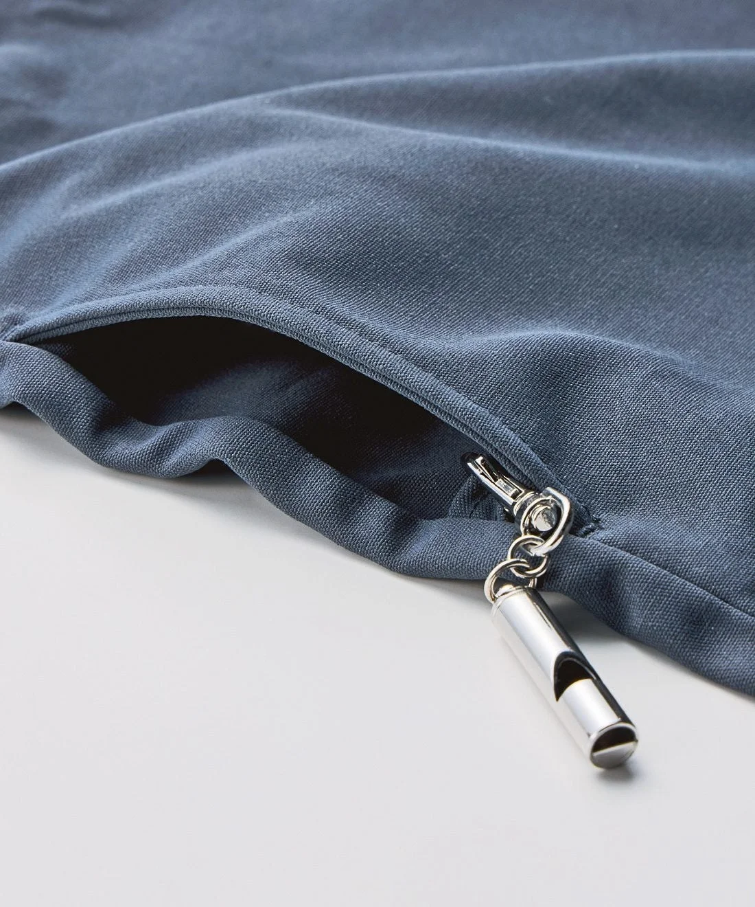 ベストのサイドポケットにホイッスルを付けた様子