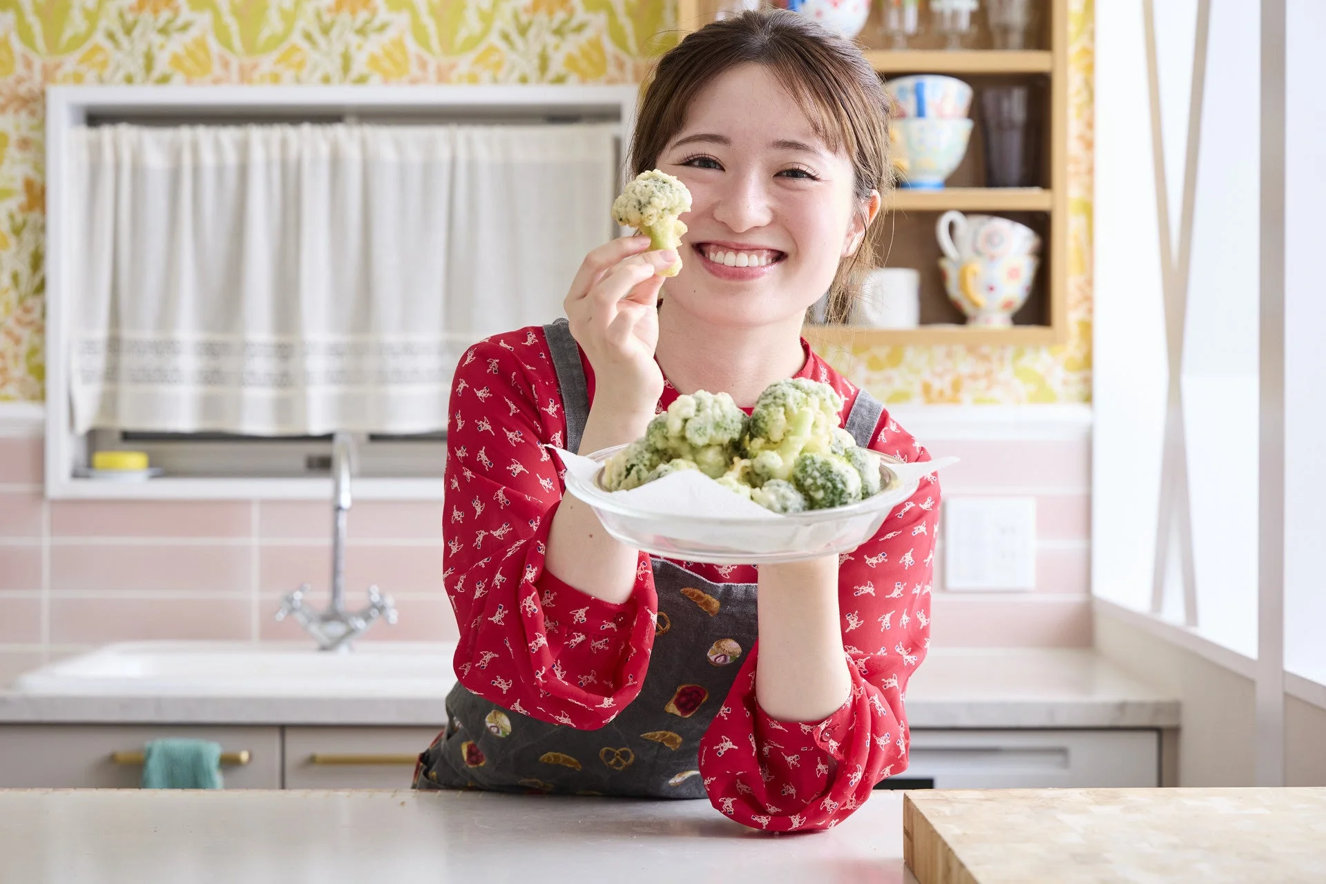 キッチンで揚げたブロッコリーを持つはるあんさん